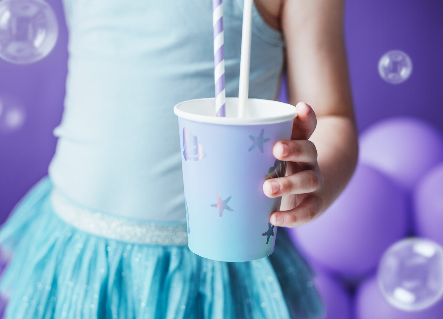 Light blue paper cups with holographic seashell and star illustrations — ocean party tableware.