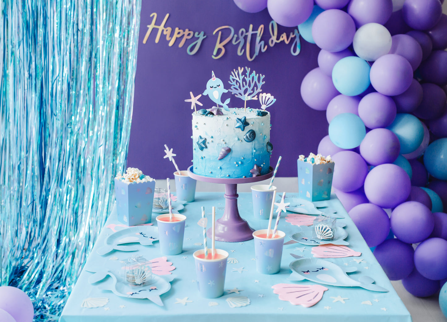 Light blue paper cups with holographic seashell and star illustrations — ocean party tableware.
