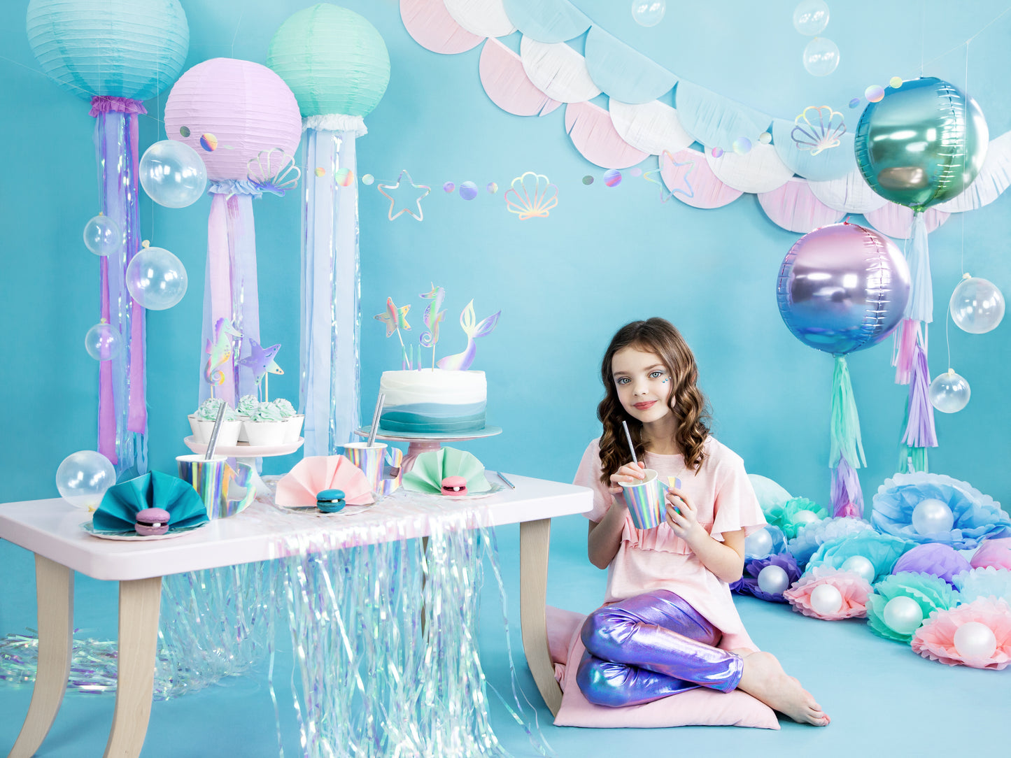 Pastel garland featuring seashell and star shapes — under the sea party banner.