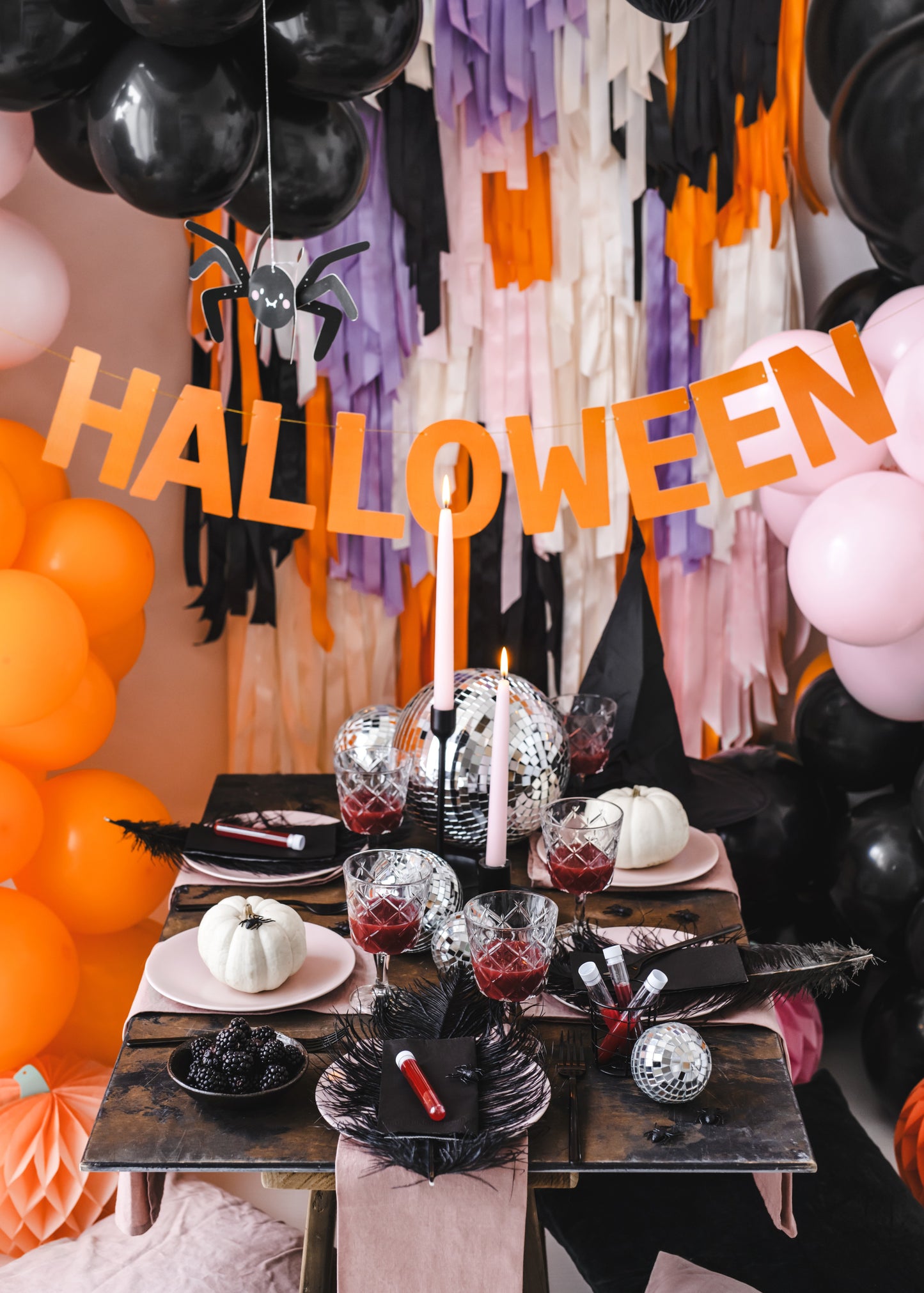 Halloween-themed table setting with decorations and balloons.