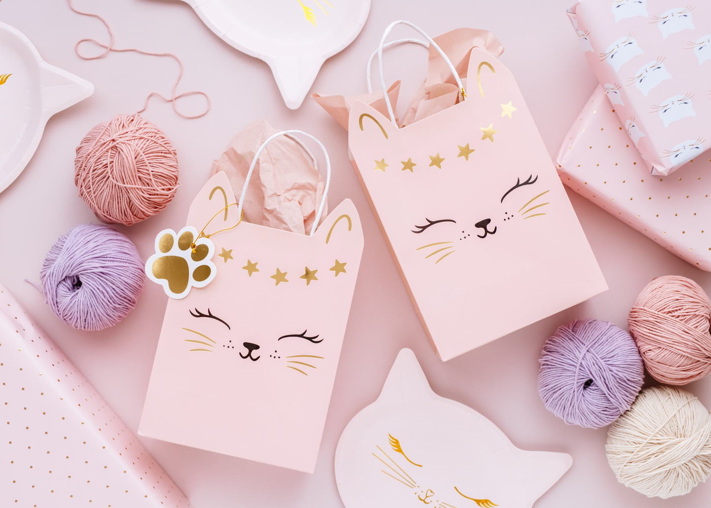 Pink gift bag with cat face and star design, ideal for party favors or birthday gifts for cat-themed celebrations.