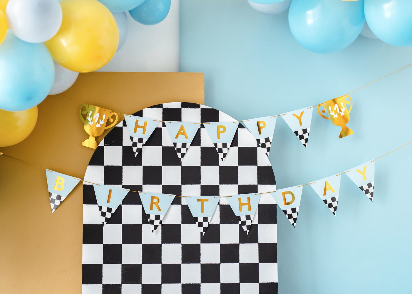 Birthday banner with checkered flags and race car motifs.