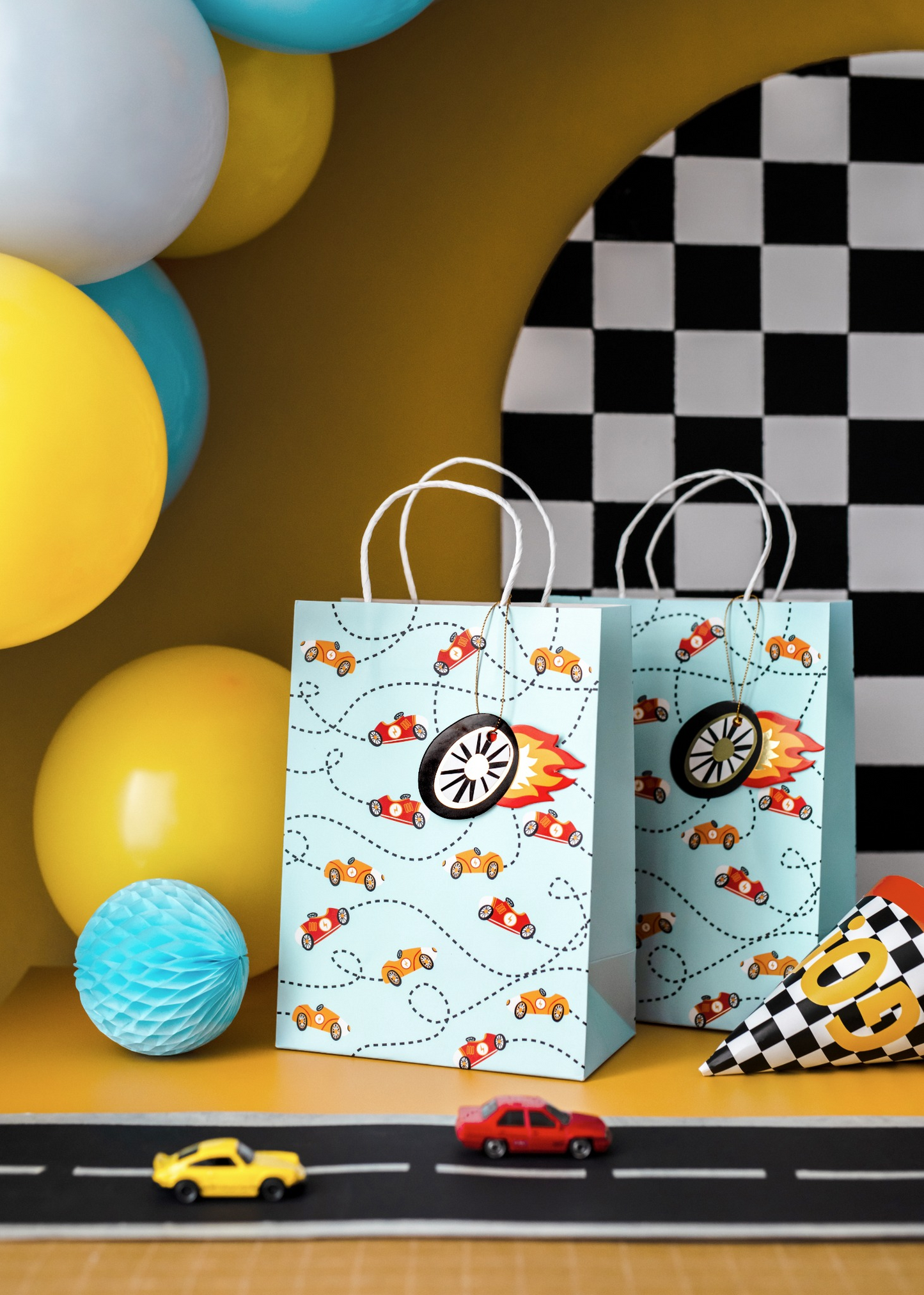 Gift bag decorated with colorful race cars and flames.