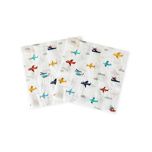 Two napkins with airplane and helicopter patterns on a white background