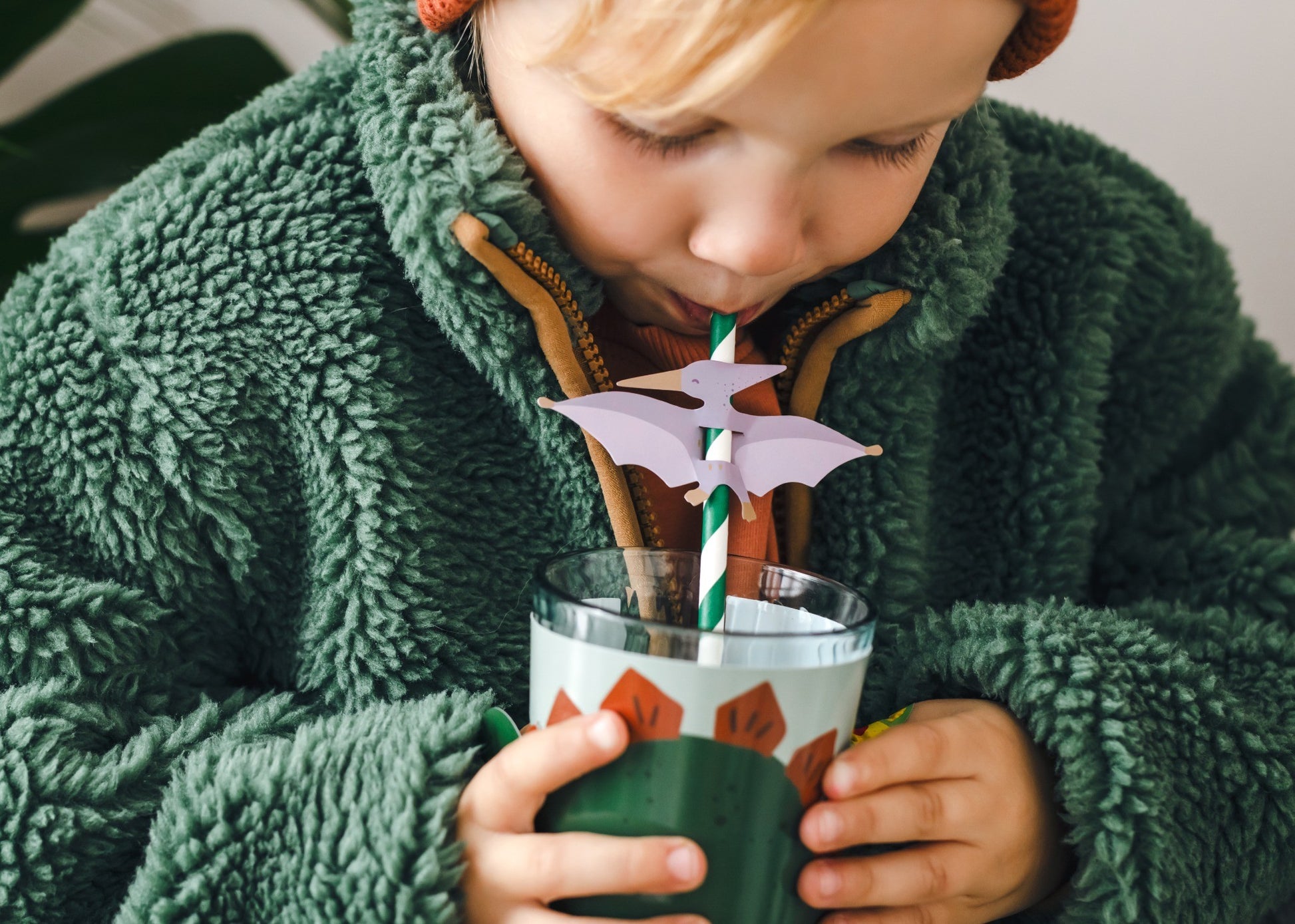 Set of green and white striped dino paper straws with pterodactyl toppers