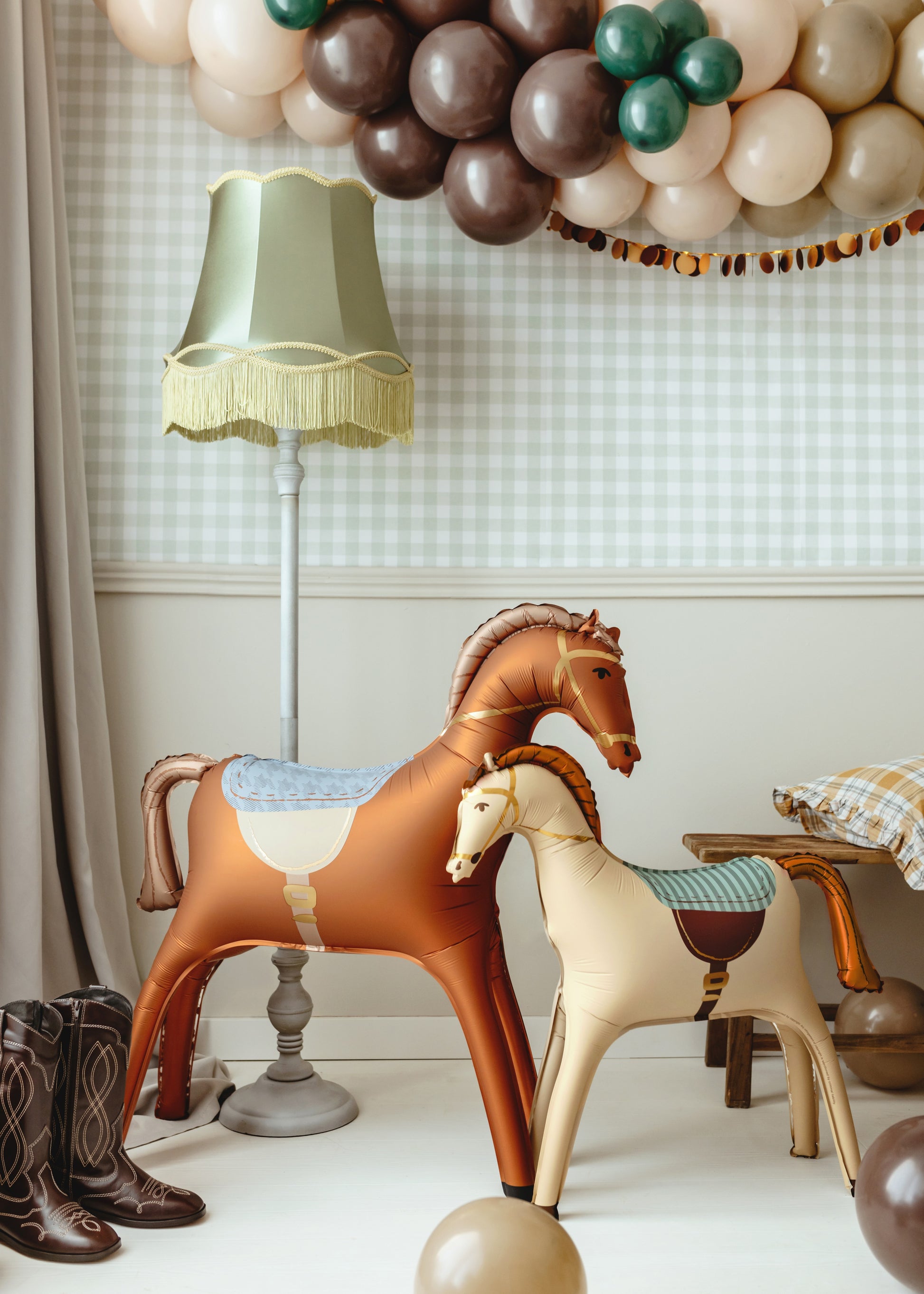Inflatable horse balloons for kids' birthday party with rustic Western decor and cowboy boots