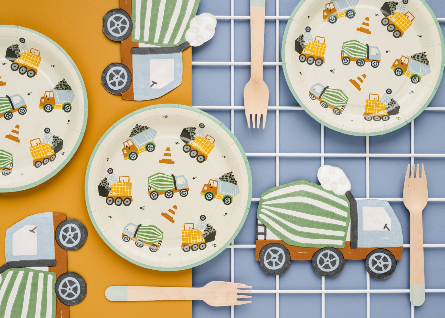 Party table setup with themed paper plates, wooden cutlery and napkins in shape of concrete mixer truck