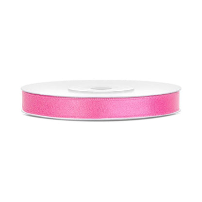Roll of dark pink ribbon on a white background