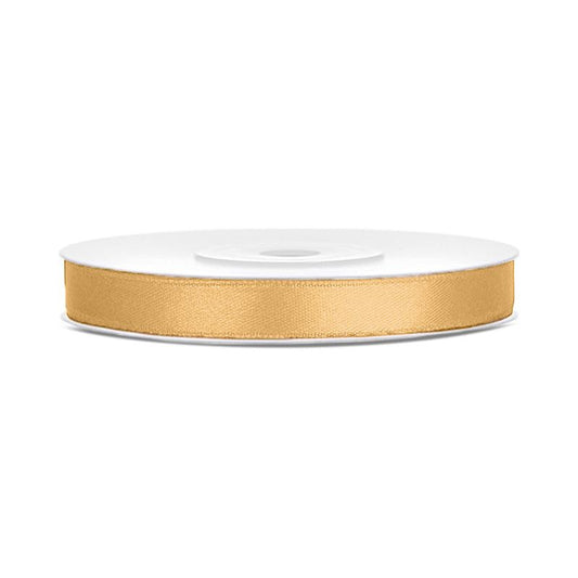 Gold ribbon on a white spool against a white background