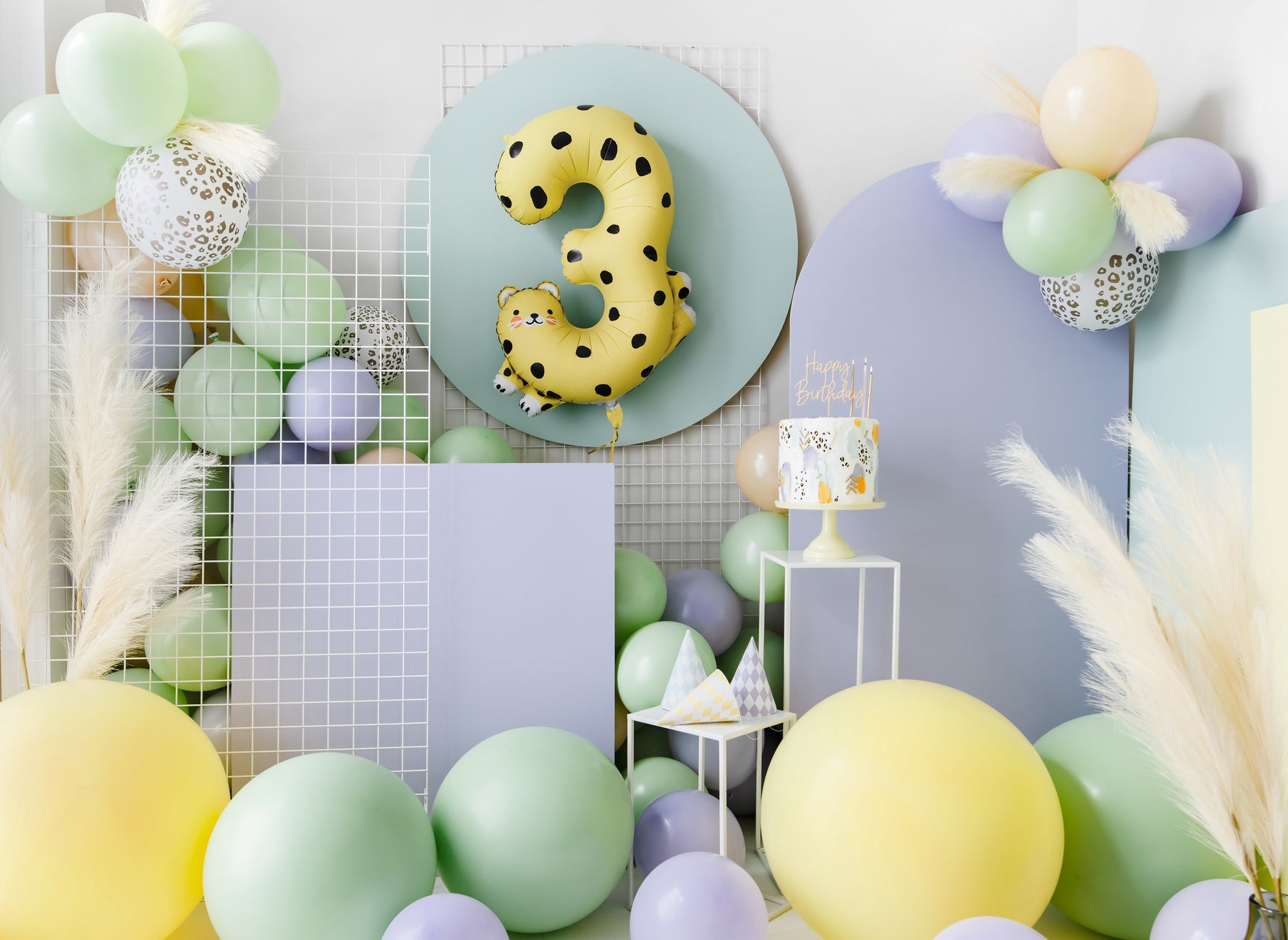 Birthday setup with balloons, a number 3 balloon, and cake with Happy Birthday topper