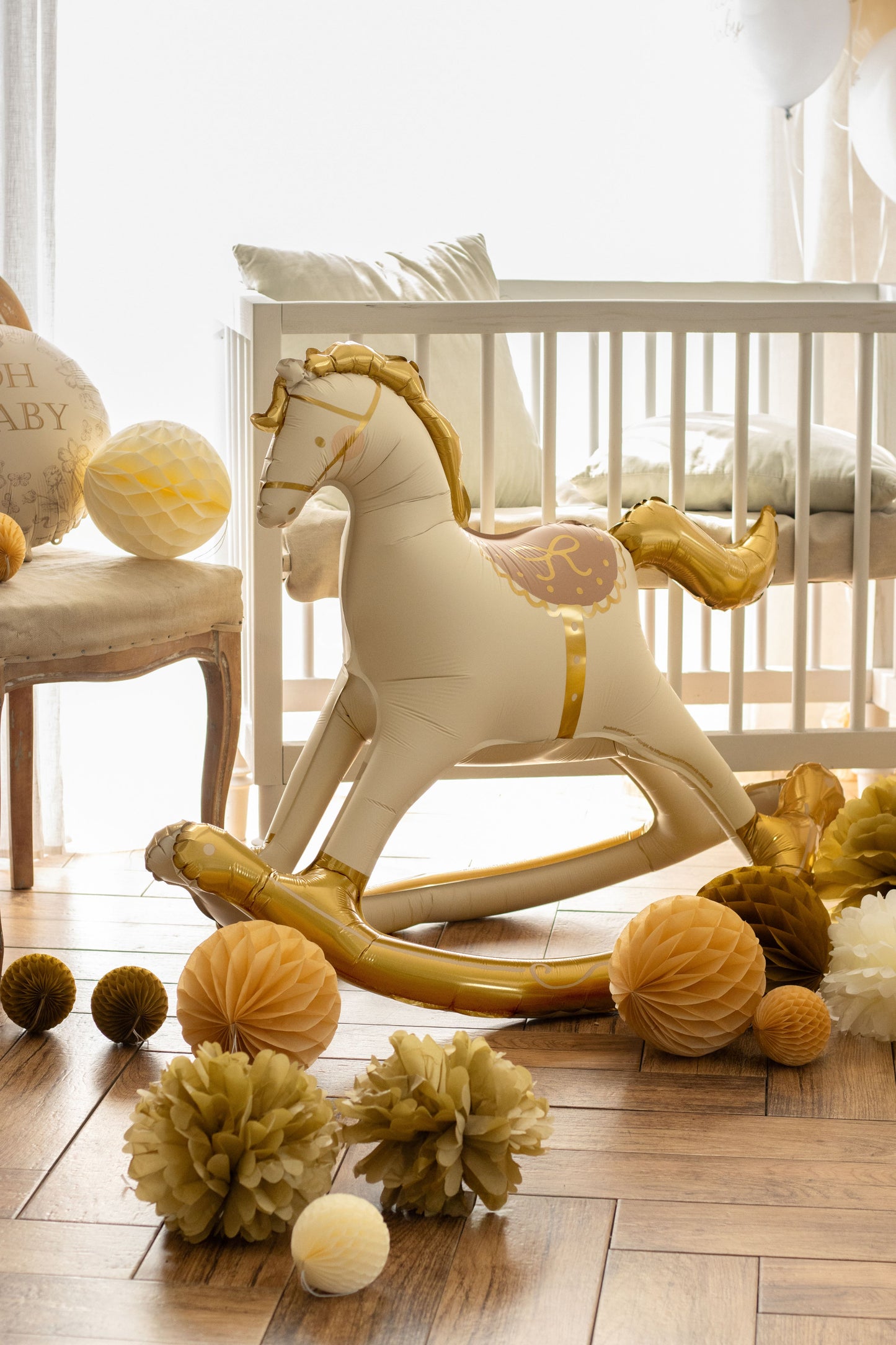 White rocking horse with gold accents in a nursery setting
