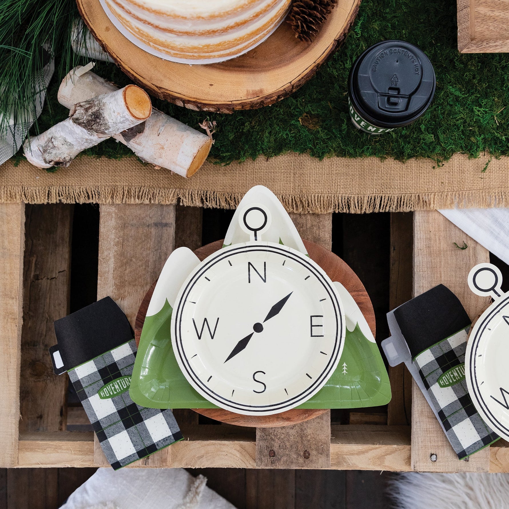 Compass plate, thermos napkins on a rustic wooden table.